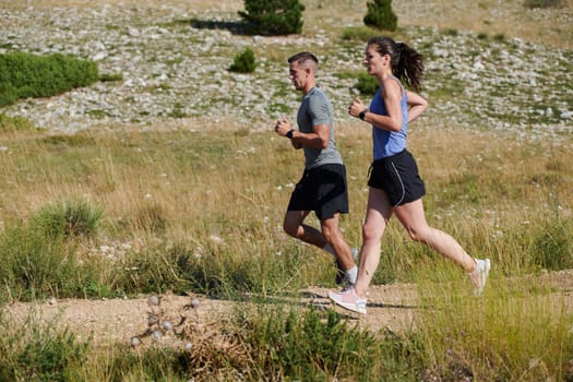 A vibrant couple dashes running the outdoors, embodying the essence of athleticism and romance, their confident strides reflecting a shared commitment to fitness and preparation for future marathon challenges.