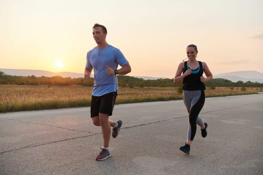 A vibrant couple dashes running the outdoors, embodying the essence of athleticism and romance, their confident strides reflecting a shared commitment to fitness and preparation for future marathon challenges.