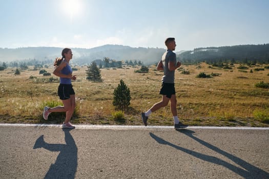 A couple runs through a sun-dappled road, their bodies strong and healthy, their love for each other and the outdoors evident in every stride.