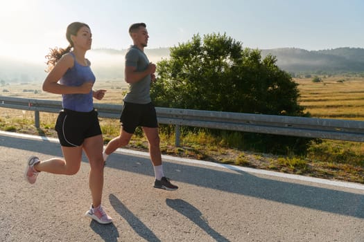 A couple runs through a sun-dappled road, their bodies strong and healthy, their love for each other and the outdoors evident in every stride.