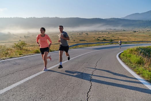 A couple runs through a sun-dappled road, their bodies strong and healthy, their love for each other and the outdoors evident in every stride.