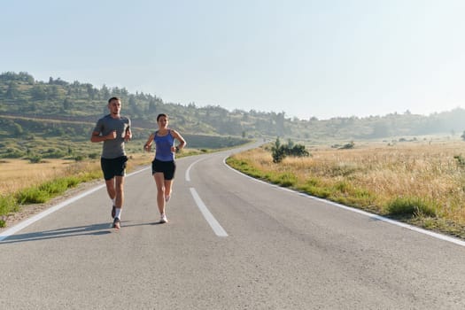 A couple runs through a sun-dappled road, their bodies strong and healthy, their love for each other and the outdoors evident in every stride.