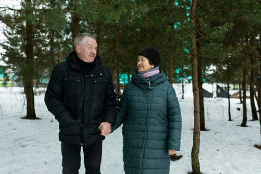 European mature family having fun walking through the winter forest.