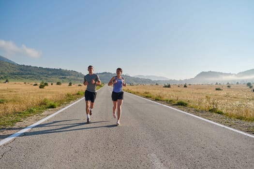 A couple runs through a sun-dappled road, their bodies strong and healthy, their love for each other and the outdoors evident in every stride.