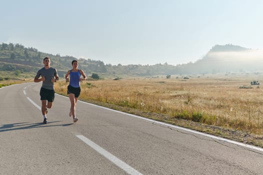 A couple runs through a sun-dappled road, their bodies strong and healthy, their love for each other and the outdoors evident in every stride.