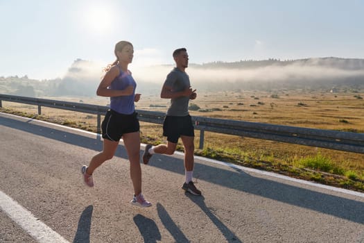 A couple runs through a sun-dappled road, their bodies strong and healthy, their love for each other and the outdoors evident in every stride.