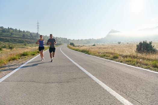 A couple runs through a sun-dappled road, their bodies strong and healthy, their love for each other and the outdoors evident in every stride.