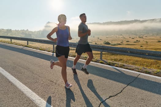 A couple runs through a sun-dappled road, their bodies strong and healthy, their love for each other and the outdoors evident in every stride.