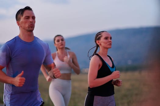 A diverse group of runners finds motivation and inspiration in each other as they train together for an upcoming competition, set against a breathtaking sunset backdrop.