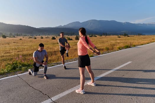 A vibrant and diverse group of athletes engage in stretching and warming up exercises, showcasing their unity and readiness for an invigorating morning run.