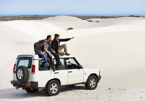Friends, people on car in desert and travel for tourism in Dubai for safari, road trip and view. Adventure, journey and transportation with offroad vehicle or 4x4 on vacation for break outdoor.