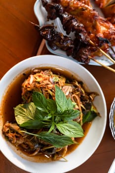 Local Thai food for people in the central region of Thailand. Spicy frog salad with vegetables and herbs. grilled chicken.