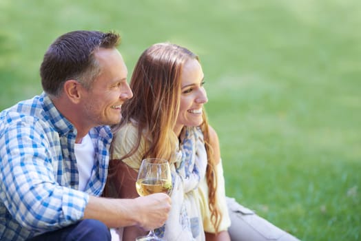 Couple, travel and wine for bonding in outdoor nature, love and romance in relationship on weekend. Alcohol, conversation and people on date in countryside, adventure and relax on grass for vacation.