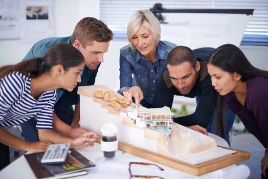 Architect, teamwork and diversity with design model, building and project with colleague people. Office, planning and working together in meeting for construction, pointing and concept for home build.