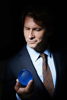 Man, suit and orb in studio for globe or earth for communication and connectivity in business. Leader or ceo with sphere, crystal or circle in hand for economy, world or future for corporate.
