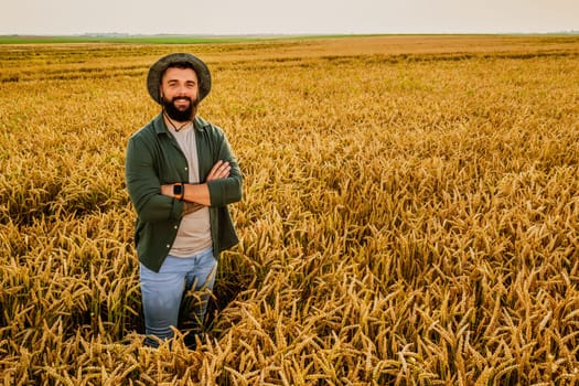 Portrait of farmer who is cultivating wheat. He is satisfied with good progress of plants. Agricultural occupation.