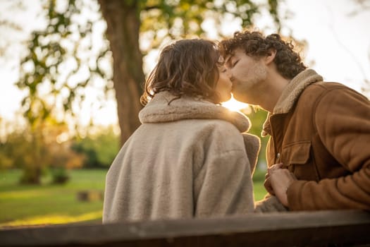 Portrait of happy loving couple in park. Man and woman kissing.