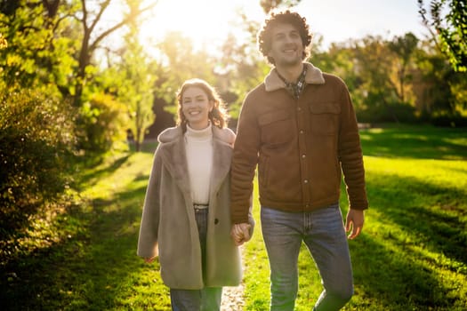 Portrait of happy loving couple walking in park in sunset.