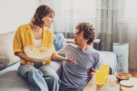 Man and woman are sitting at sofa and arguing. Relationship problems.