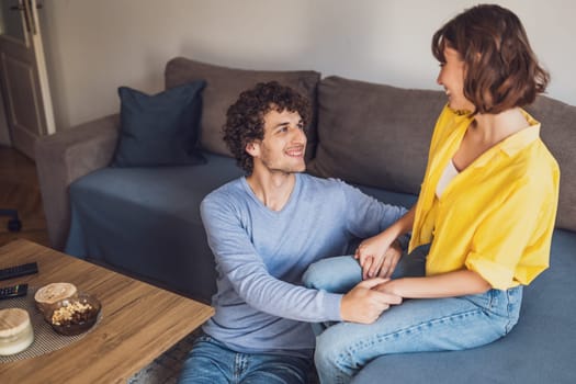 Portrait of young happy couple who is holding hands and smiling.