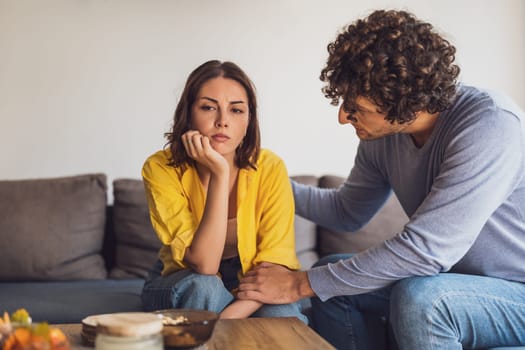 Man and woman are sitting at sofa and arguing. Relationship problems.