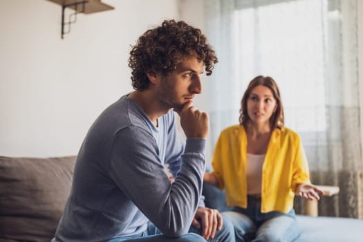 Man and woman are sitting at sofa and arguing. Relationship problems.