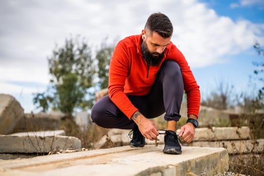 Young man is tying a shoelace before jogging.