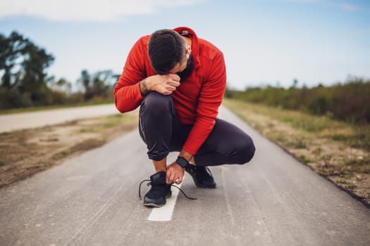 Young man is having pain in ankle while exercising and jogging outdoor.