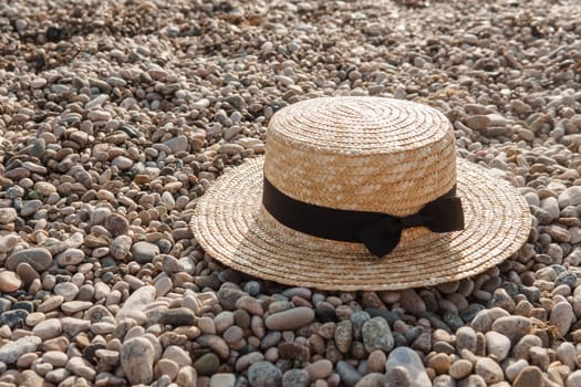 A straw hat on the beach. Pebbles on the seashore, close-up. The natural background.