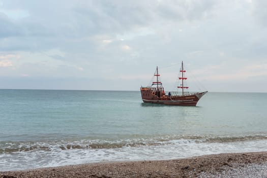 Sailing ship sailing to the shore, marine tourism. Beach holidays on the Black Sea. Fabulous moments of a sunny day