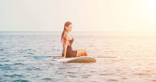 Sea woman sup. Silhouette of happy young woman in pink bikini, surfing on SUP board, confident paddling through water surface. Idyllic sunset. Active lifestyle at sea or river. Slow motion