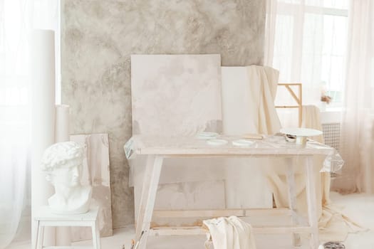 The interior of the art workshop is decorated in bright colors. Working materials of the artist and the sculptor