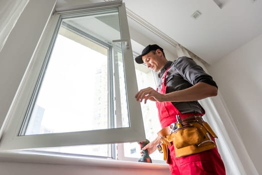 craftsmen workers install a window in the house rattle with a special rubber hammer. High quality photo
