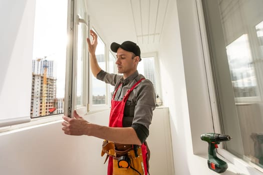 Master's work. Close-up of young handyman setting new windows at the appartment. High quality photo