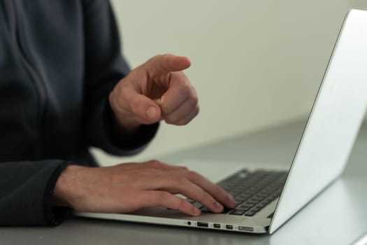 Businessman closeup finger point at laptop display on desk, hand typing on keyboard, blurred background. Concept of online shopping, offer and recommend