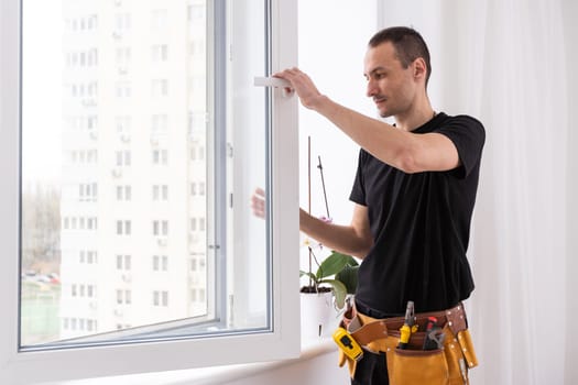 male industrial builder worker at window installation in building construction site. High quality photo