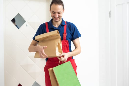 Two boxes with fast food being carried by delivery man in uniform for one of clients. High quality photo