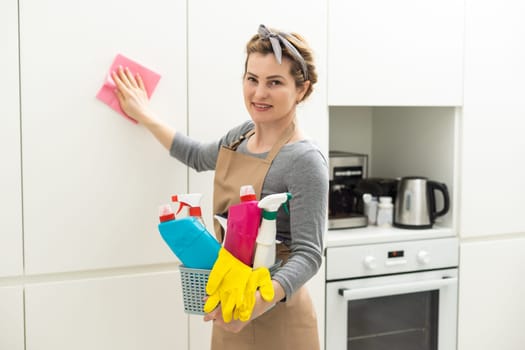Woman cleaning table using rag and diffuser at home
