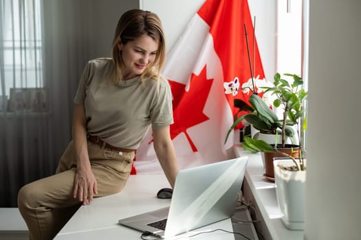 woman hands and flag of Canada on computer, laptop keyboard . High quality photo