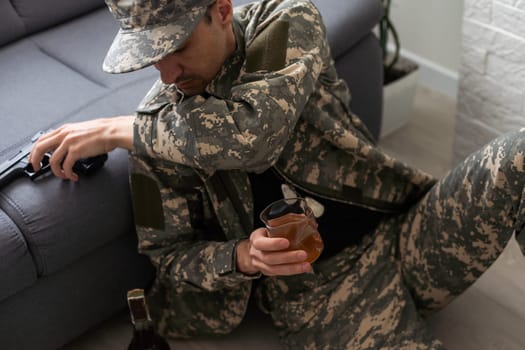 young attractive wasted and depressed addict and alcoholic man with whiskey glass thoughtful and sad failing resisting temptation to drink falling into alcohol abuse addiction and alcoholism problem . High quality photo