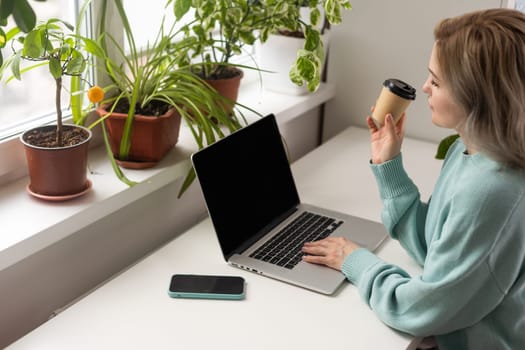 woman with laptop and takeaway coffee.