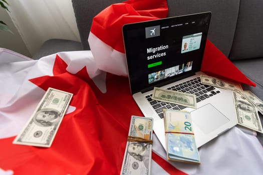 laptop with migration service and Canadian flag.