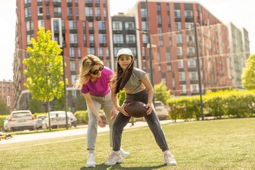 mother and daughter playing american football.