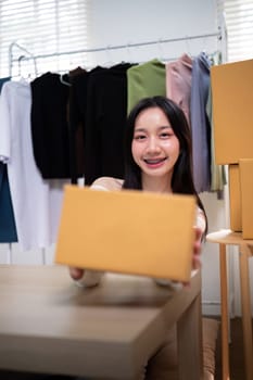 Happy young asian woman startup small business freelance holding parcel box. Online marketing packing box delivery concept.