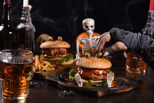 The witches hand holds the eye of Monstera Burger on a sitting skeleton. Perfect Halloween Party appetizer