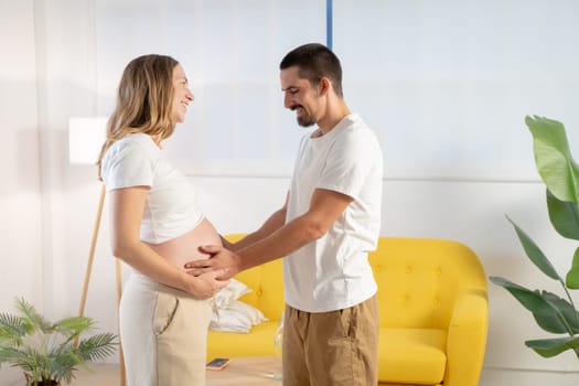 Pregnancy couple smiling happily touching belly. High quality photo