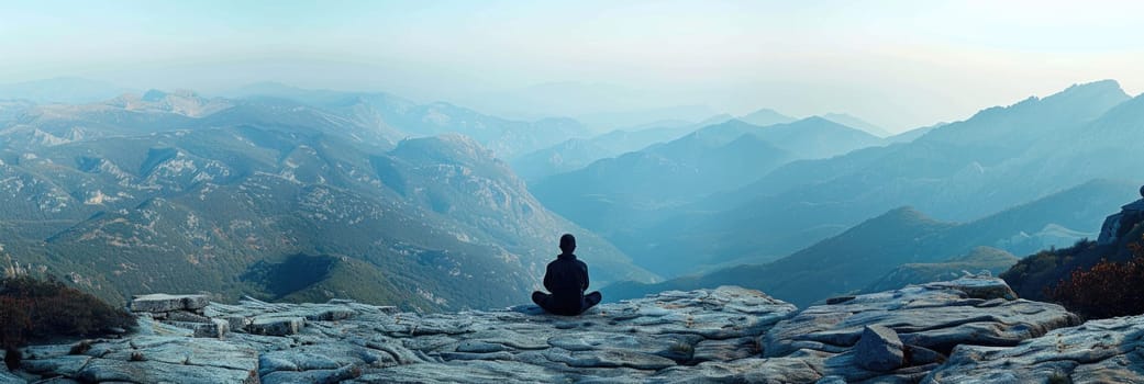 A person is seated on a rocky mountain summit, enjoying the view and the moment.