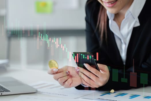 A woman is holding a coin and looking at her phone. Concept of focus and determination as she looks at her phone, possibly checking stock prices or financial information. The woman's attire