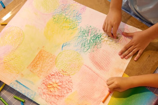 Top view close-up kids drawing with pastel color pencils on cardboard paper, learning painting during art class lesson in a creative workshop. People. Creative hobby for children. Education