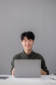 Portrait of a handsome young office worker intently studying how to do a presentation project on a laptop in his office..